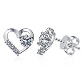 Silver heart-shaped earrings with clear gemstones on a white background