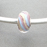 Marbled glass bead on a silver rod against a grey background