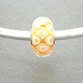 honeycomb design bead on a silver bangle on a grey background