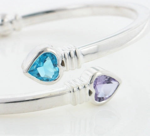 Close up of heart-shaped blue and purple gemstones on a white background
