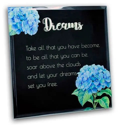 Decorative plaque with blue flowers and motivational quote about dreams on a black background