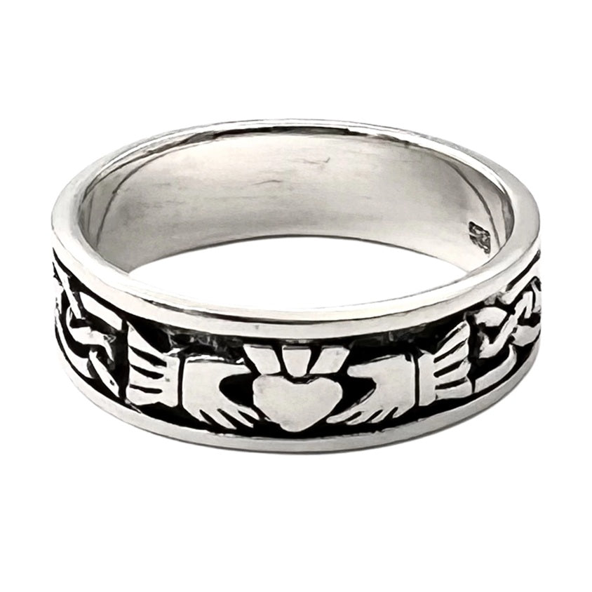 Silver claddagh band ring with intricate design on a white background