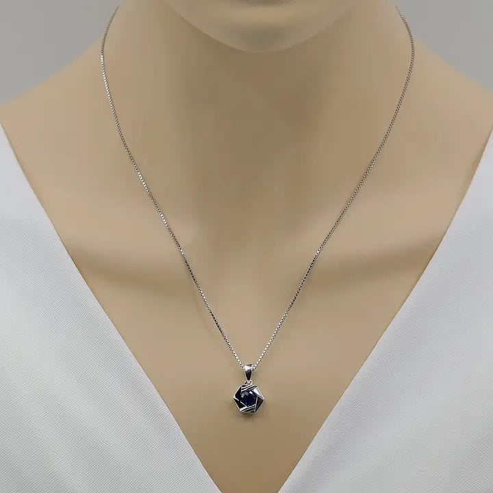 Silver necklace with a blue pendant on a mannequin neck against a white background