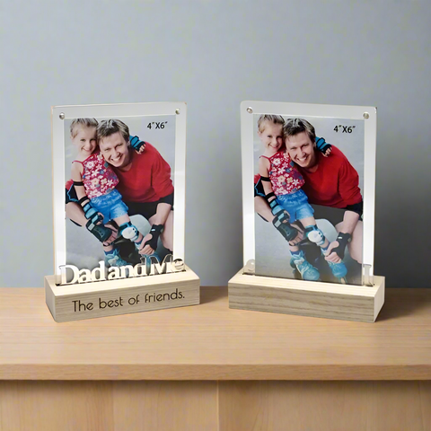 Two photo frames with a picture of a father and child, placed on a wooden surface.