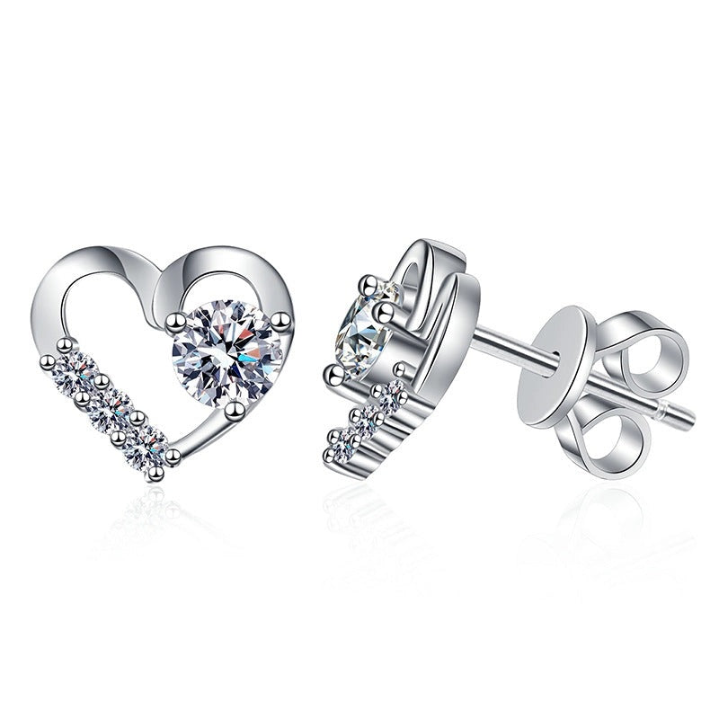 Silver heart-shaped earrings with clear gemstones on a white background
