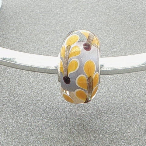 Silver bangle with a leafy designed murano glass bead against a grey background