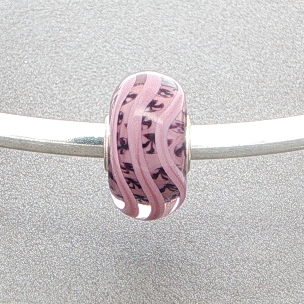 Pink mauve glass bead with inner detail on a silver bangle on a grey background